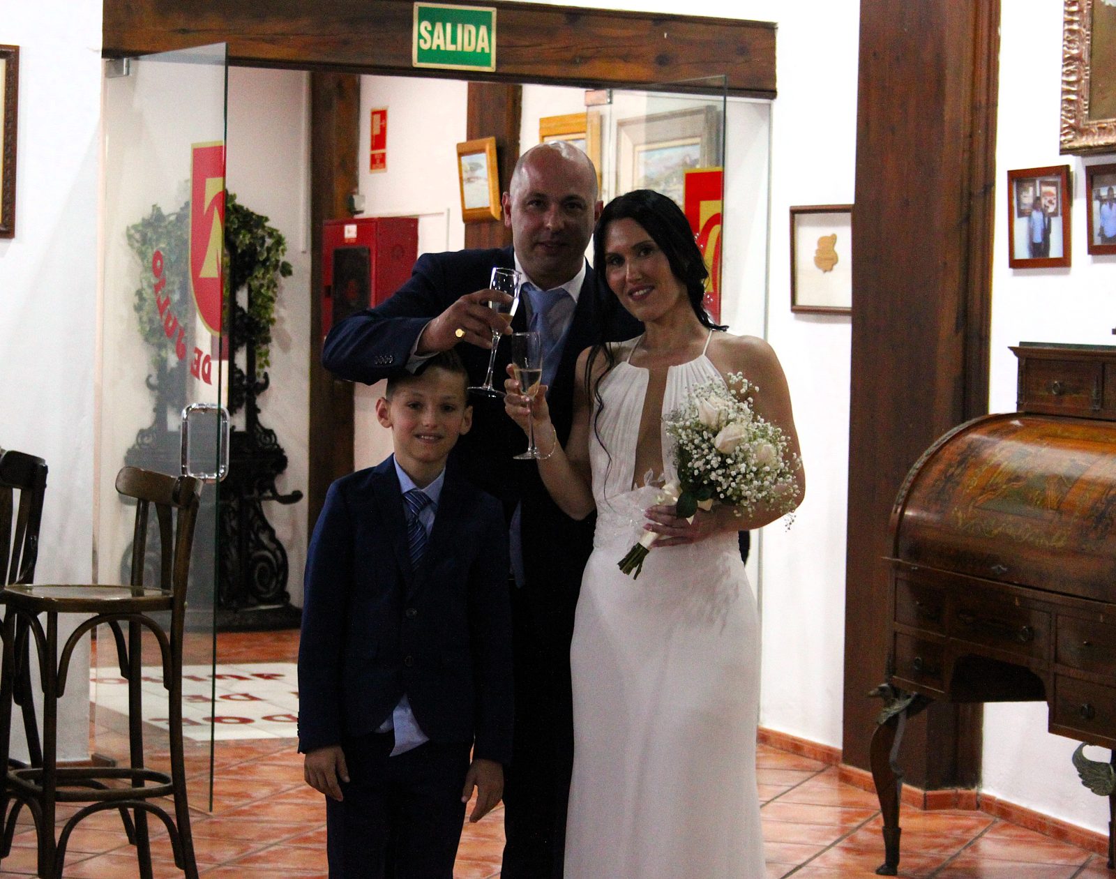 Los novios y su hijo brindan a la entrada