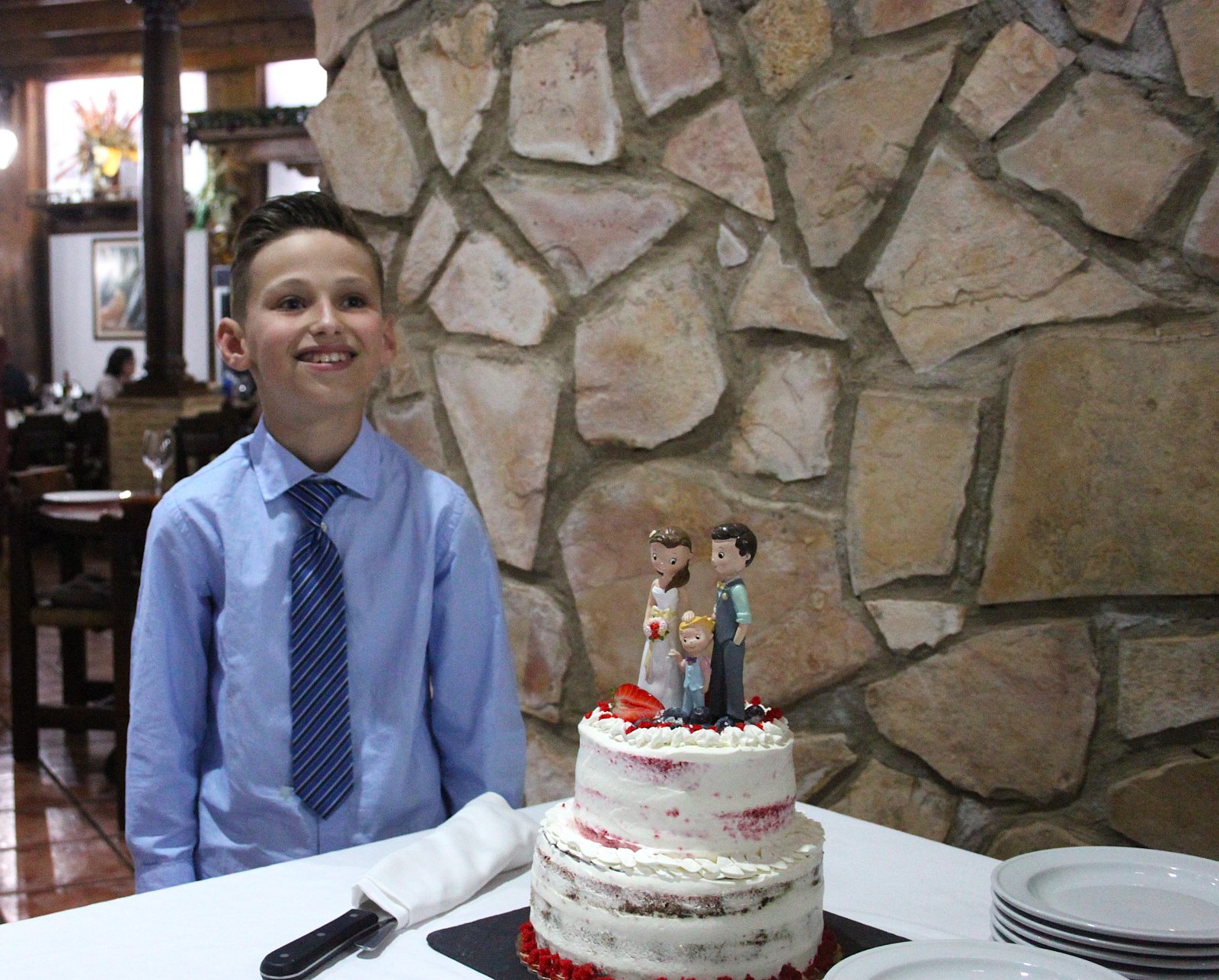 El niño, feliz junto a la tarta de boda